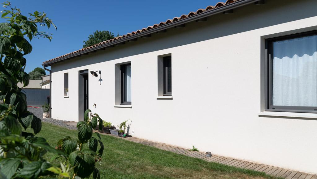 Vue extérieure de maison neuve à Chauray avec enduit clair et garage à part